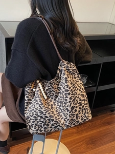 Grand sac cabas à motif léopard avec accessoire perlé présenté dans un décor moderne