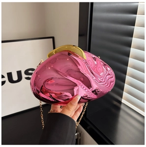 Detailed shot of rose red acrylic evening bag with gold chain and glossy mirror finish