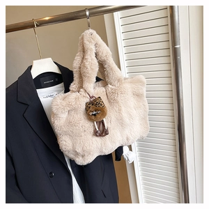 Détail d'un sac cabas en peluche beige avec un pendentif chat mignon au motif léopard chic