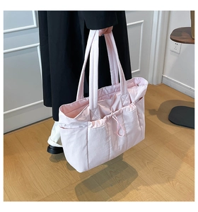 Vue détaillée du sac cabas rose montrant la poche avant à cordon et la texture en nylon