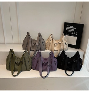 Vue détaillée de grands sacs à bandoulière en nylon avec poches zippées et larges sangles