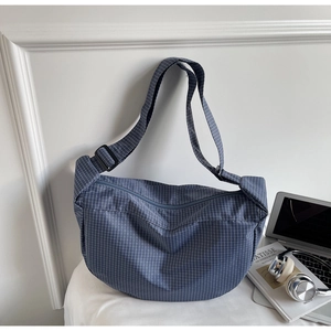 Dettaglio della borsa a tracolla a scacchi blu-grigio con cinturino regolabile