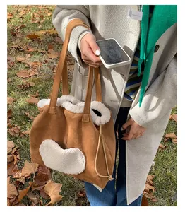 Detailed view of brown faux suede tote bag with plush sherpa trim and heart patch