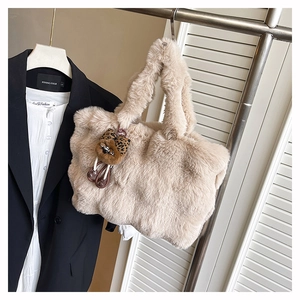 Détail du sac fourre-tout en peluche beige avec breloque ours léopard sur cintre en métal