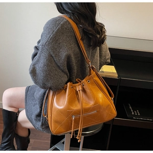 Détail d'un sac à dos seau matelassé vintage avec cordon de serrage et poches zippées