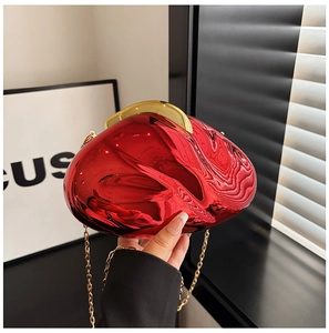 Close-up of bright red metallic pebble-shaped acrylic clutch bag with gold chain
