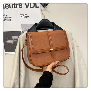 Detailed view of the brown vintage crossbody bag with gold metal lock and fabric texture