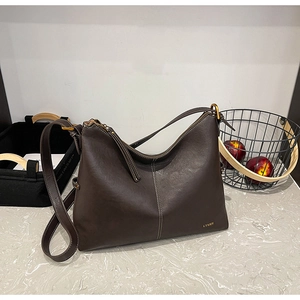 Detail view of deep brown leather hobo bag with zipper closure and metallic buckle