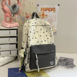 Detail of star pattern backpack with cute pendants and front zipper pocket