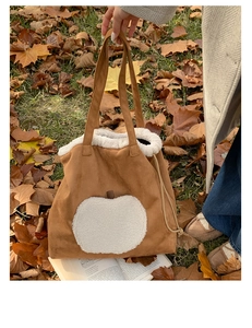 Detail of autumn brown suede tote bag with white fleece apple patch and drawstring accent