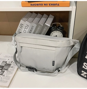 Détail du sac à bandoulière en nylon à carreaux gris clair avec sangle réglable