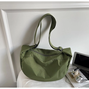 Dettaglio della borsa hobo a scacchi verdi con trama in nylon e tracolla regolabile