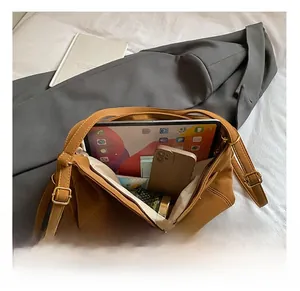 Top view showing the spacious interior of the brown tote bag holding a tablet and phone