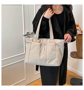 Détails du grand sac cabas beige en nylon avec cordon décoratif et poches latérales