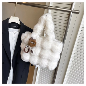 Détail du sac fourre-tout matelassé en peluche blanche avec fausse fourrure et breloque