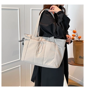 Détail du grand sac cabas gris avec cordon de serrage et poches latérales au décor intérieur