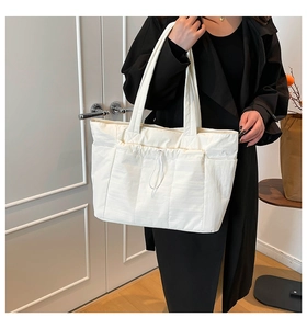 Vue détaillée d'un grand sac cabas blanc avec poche avant à cordon de serrage pratique