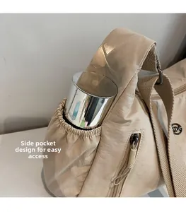 Détail de la poche latérale d'un sac en nylon beige contenant une gourde en inox