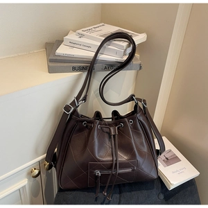 Détail d'un sac seau marron foncé matelassé avec cordon de serrage et fermeture éclair