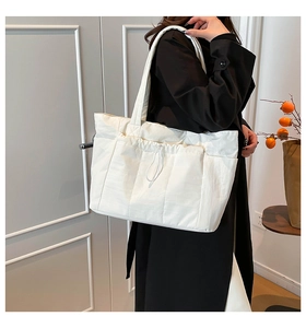 Vue détaillée du grand sac cabas blanc avec cordon de serrage et poches pour le trajet