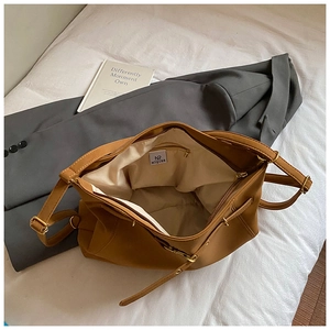 Detail of vintage brown leather tote showing inner fabric lining and functional zip pocket