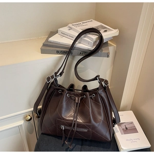 Détail du sac seau en cuir matelassé marron foncé avec cordon de serrage et poche zippée
