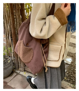 Detail view of a large vintage tote bag featuring a fleece pocket and drawstring closure