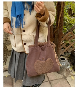 Detail of brown faux suede tote bag featuring a beige fleece apple patch and drawstring