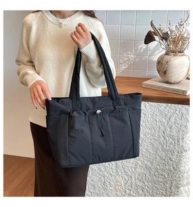Détail d'un sac cabas noir en nylon avec poches fonctionnelles et cordon de serrage pratique