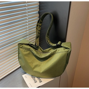 Dettaglio della borsa a scacchi verde con tracolla regolabile e texture in nylon