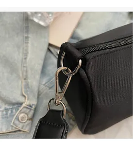 Close-up of durable silver metal hardware and fine stitching on a black canvas bag