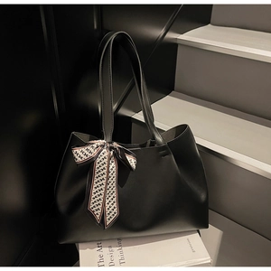 Close-up of black matte tote bag with elegant H-pattern silk scarf on stairs