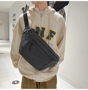 Détail du sac bandoulière en nylon à carreaux avec étiquette RUFAN et sangle