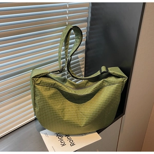 Dettaglio della borsa a tracolla verde a scacchi con texture in nylon e tracolla