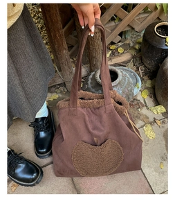 Detailed view of brown faux suede tote bag featuring a heart-shaped fleece patch
