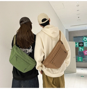 Vue de dos de sacs bandoulière en nylon à carreaux vert et kaki portés par un couple