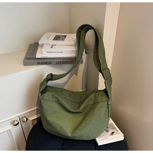 Dettaglio della borsa dumpling in nylon a scacchi verdi con ampia capacità e tracolla
