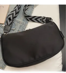 Close-up of black canvas pillow bag with geometric pattern wide shoulder strap detail