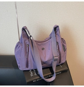 Détail du sac fourre-tout en nylon violet imperméable avec poches latérales sur livres