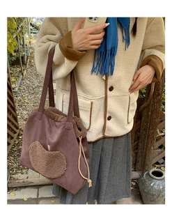 Detail of drawstring faux shearling tote bag in dark brown with plush heart patch