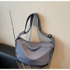 Dettaglio della borsa a tracolla a quadretti blu con cinturino regolabile
