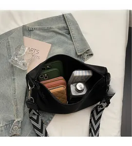 Top view of a black canvas crossbody bag showing large capacity for phones and wallets