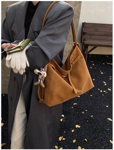 Detail of tan PU leather tote bag with metal buckle and cute animal charm on side