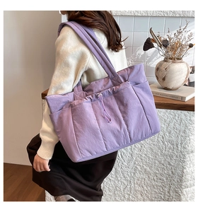 Détail du sac cabas en nylon matelassé violet montrant les coutures et le cordon de serrage