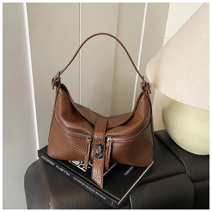 Macro shot of a vintage brown leather hobo bag texture and zipper details on books