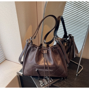 Détail du sac à dos matelassé marron foncé avec cordon de serrage et motifs en losanges