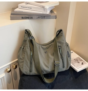 Gros plan sur un sac en nylon vert olive avec poches zippées et tissu durable et froissé