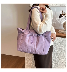 Vue détaillée du sac cabas en nylon violet avec plis à cordon et poches latérales