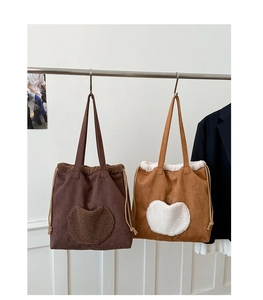 Detail of plush heart pockets on faux suede tote bags with drawstring closure