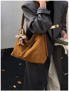 Detail of dark brown leather hobo bag with adjustable strap and cute rabbit pendant